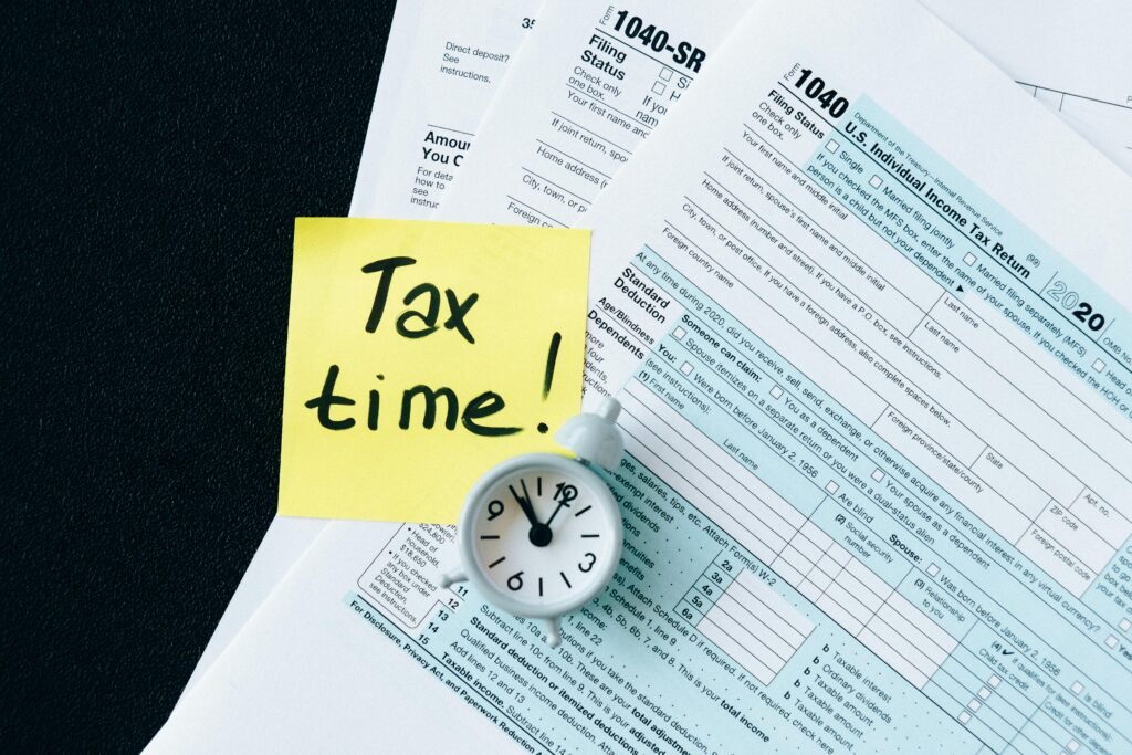 A stack of tax forms with a clock and