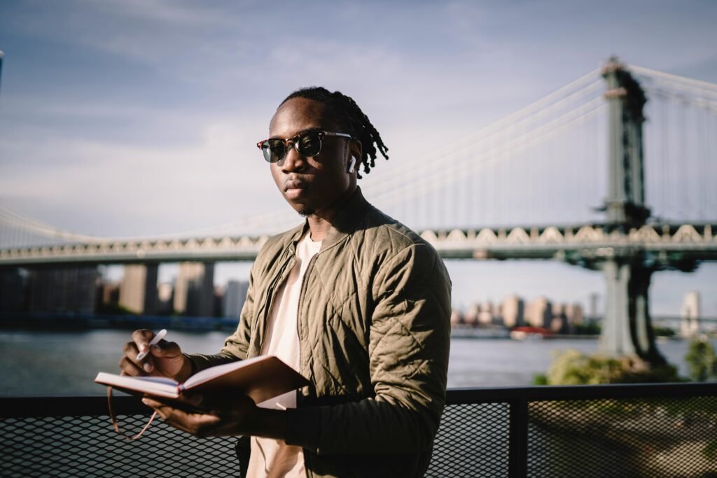A young man with sunglasses writing in